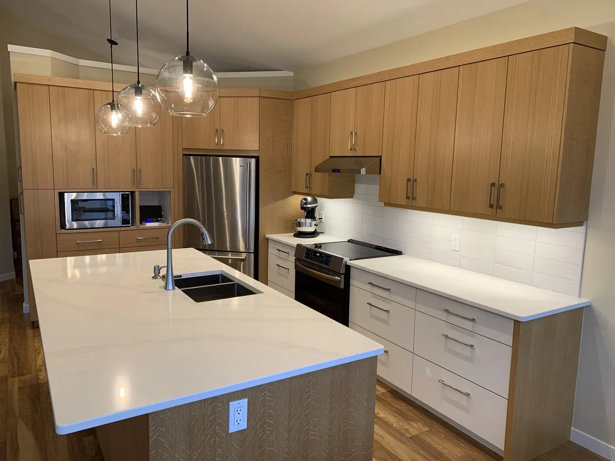 The Siggelkowski kitchen in Nanaimo, a full custom build with rift-cut oak cabinetry, a large quartz island and glass pendant lighting