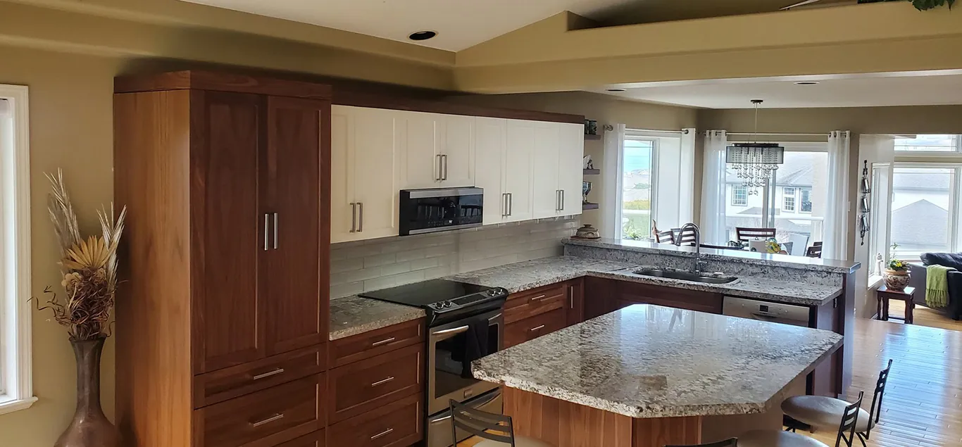 A finished Birdseye kitchen with walnut lower cabinets, white shaker uppers and an island with bar seating