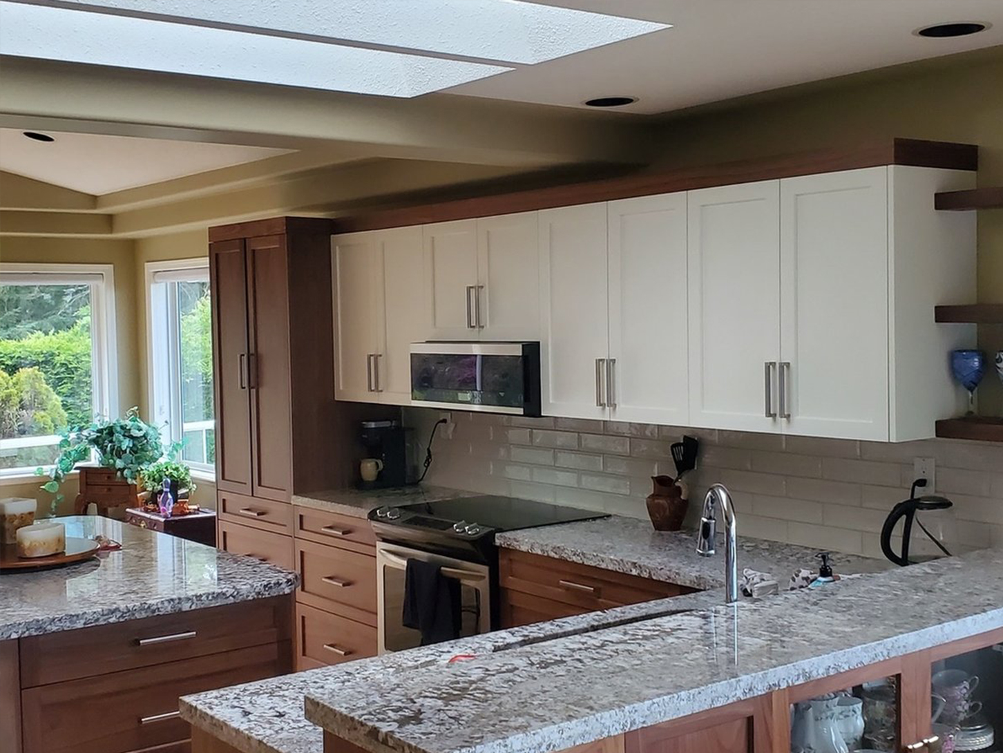The Bender kitchen in Nanaimo after its partial renovation, with White Dove upper cabinets, solid black walnut lower cabinets and a matching walnut pantry tower