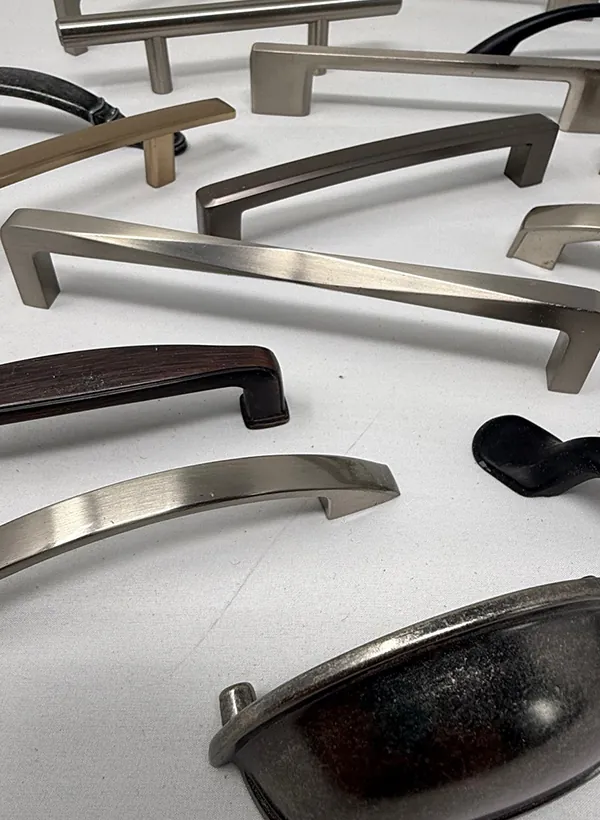 A spread of cabinet handle samples in brushed nickel, matte black, bronze and brass