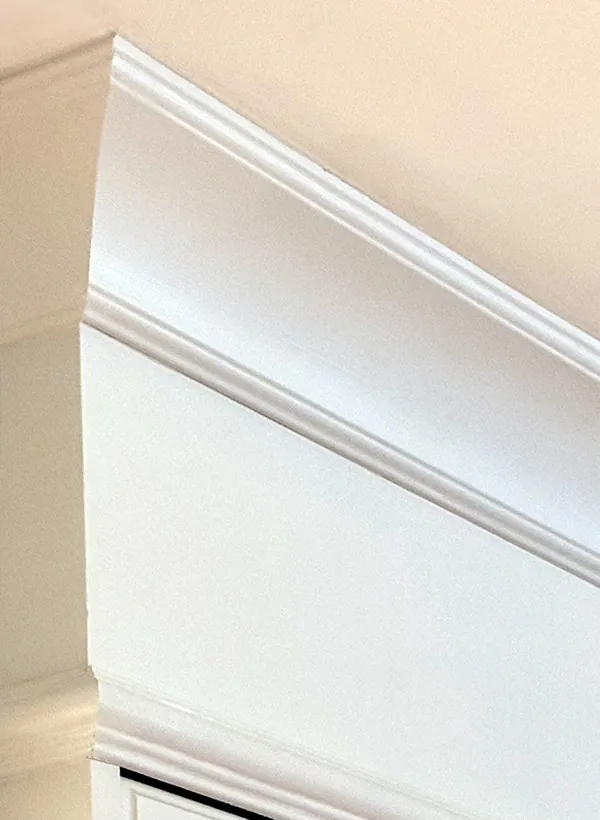 Painted crown moulding finished tight to the ceiling above refaced cabinets