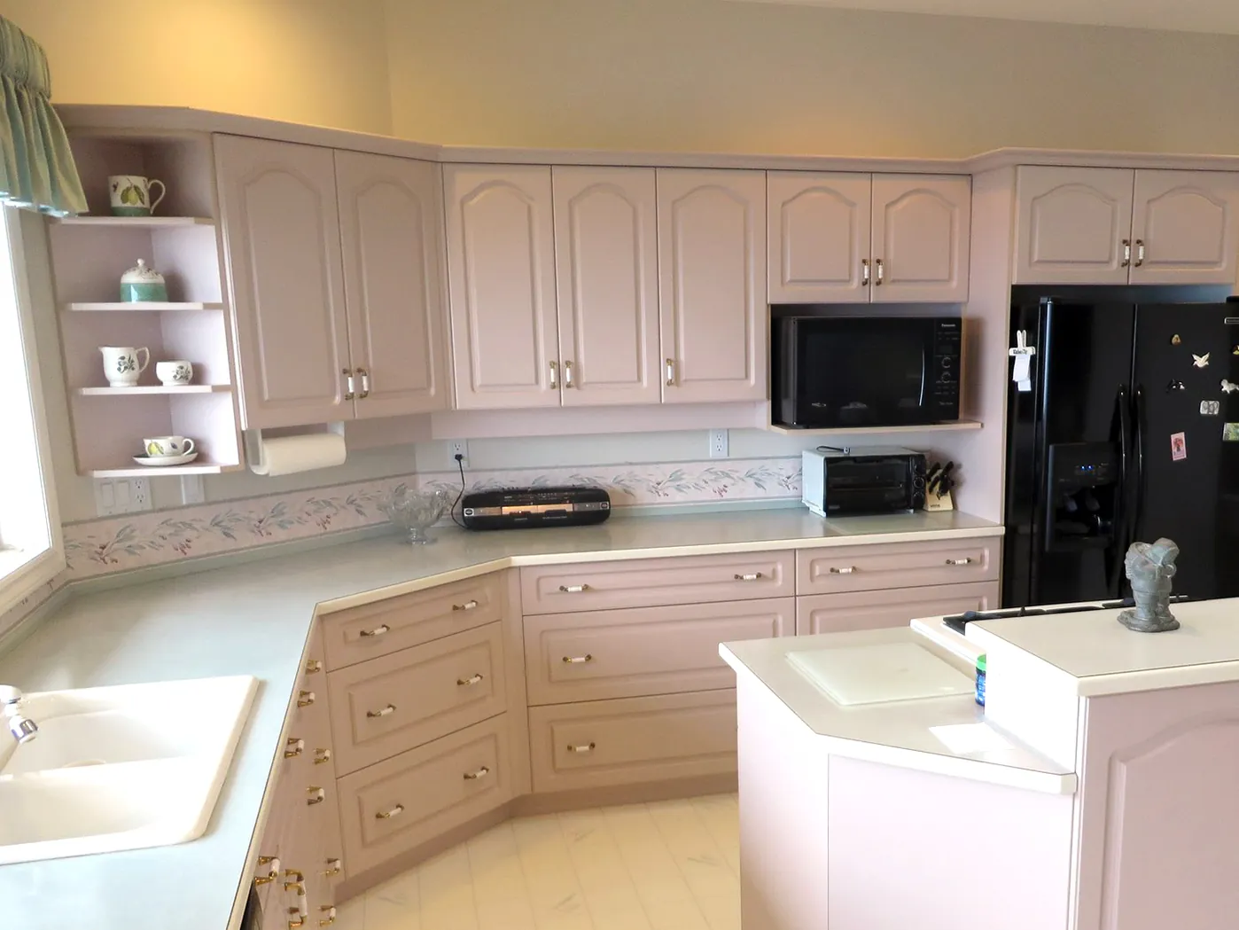 The O'Malley kitchen before refacing, with 1990s arched raised-panel doors and laminate counters